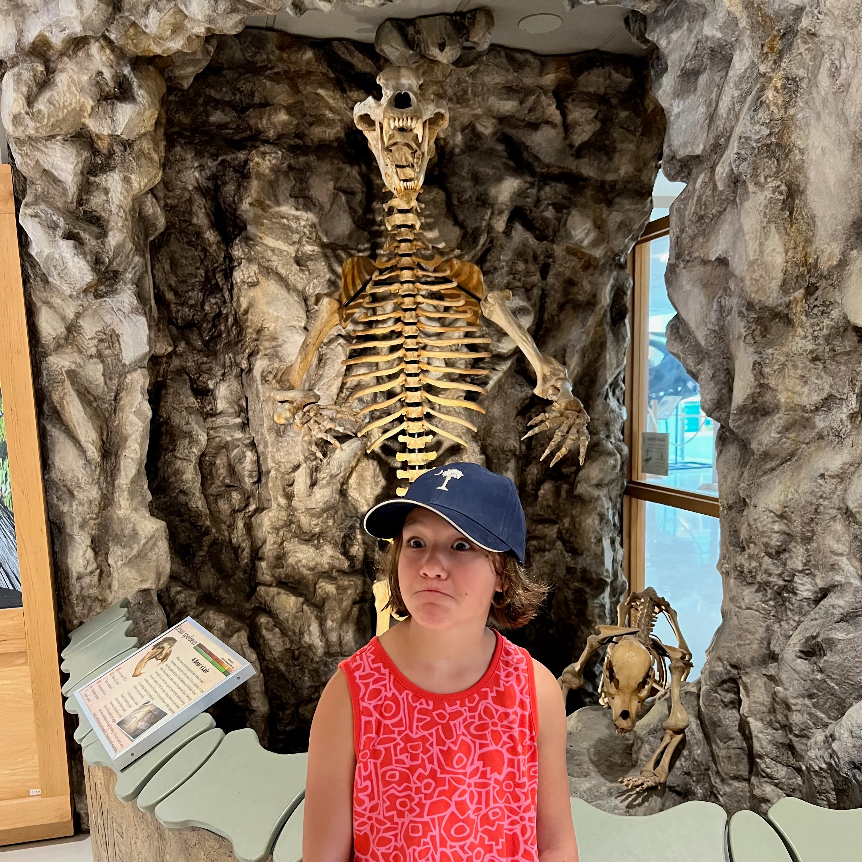 Lorelei making faces in front of a cave bear skeleton.